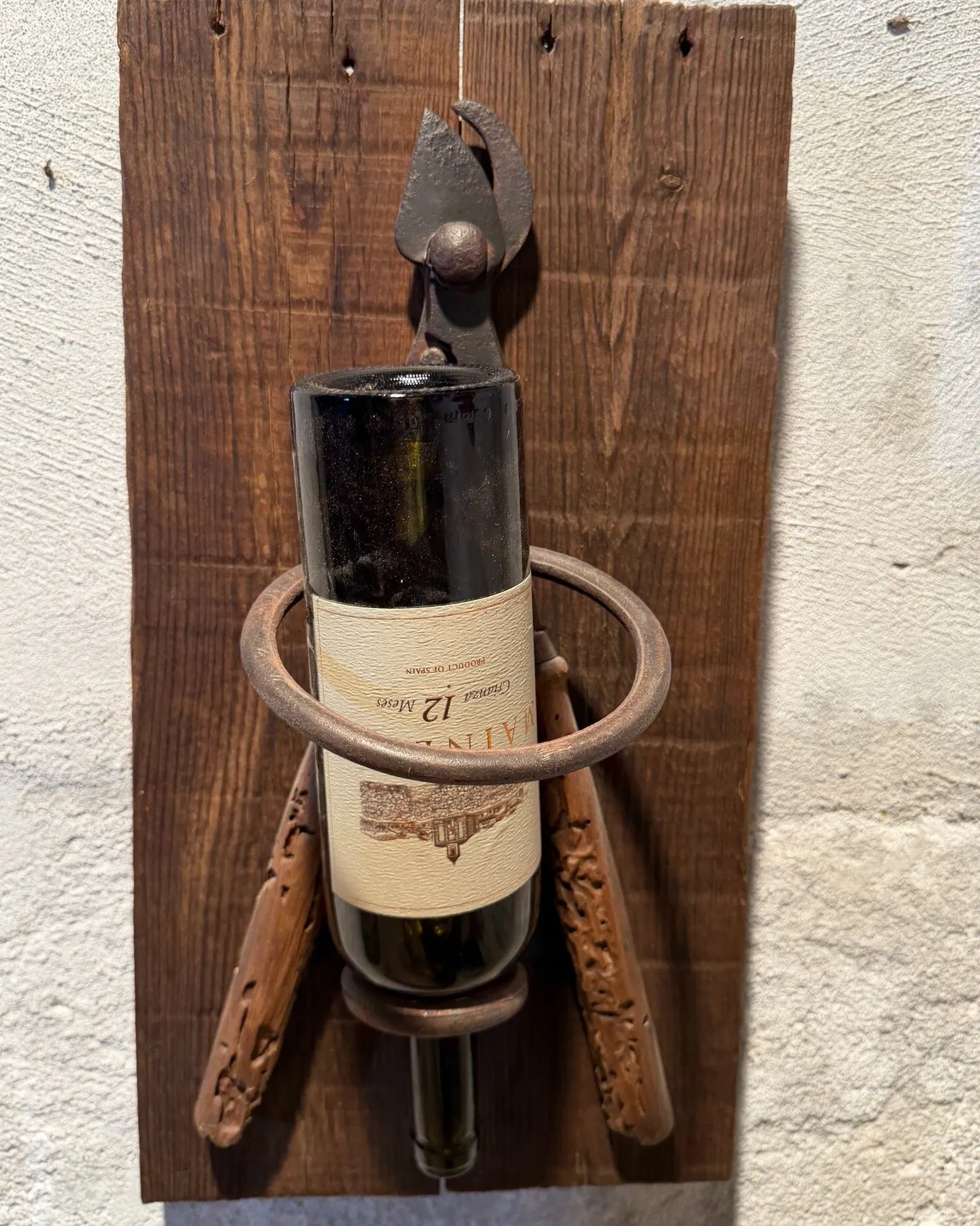 El botellero de tenaza sujetando una botella de vino