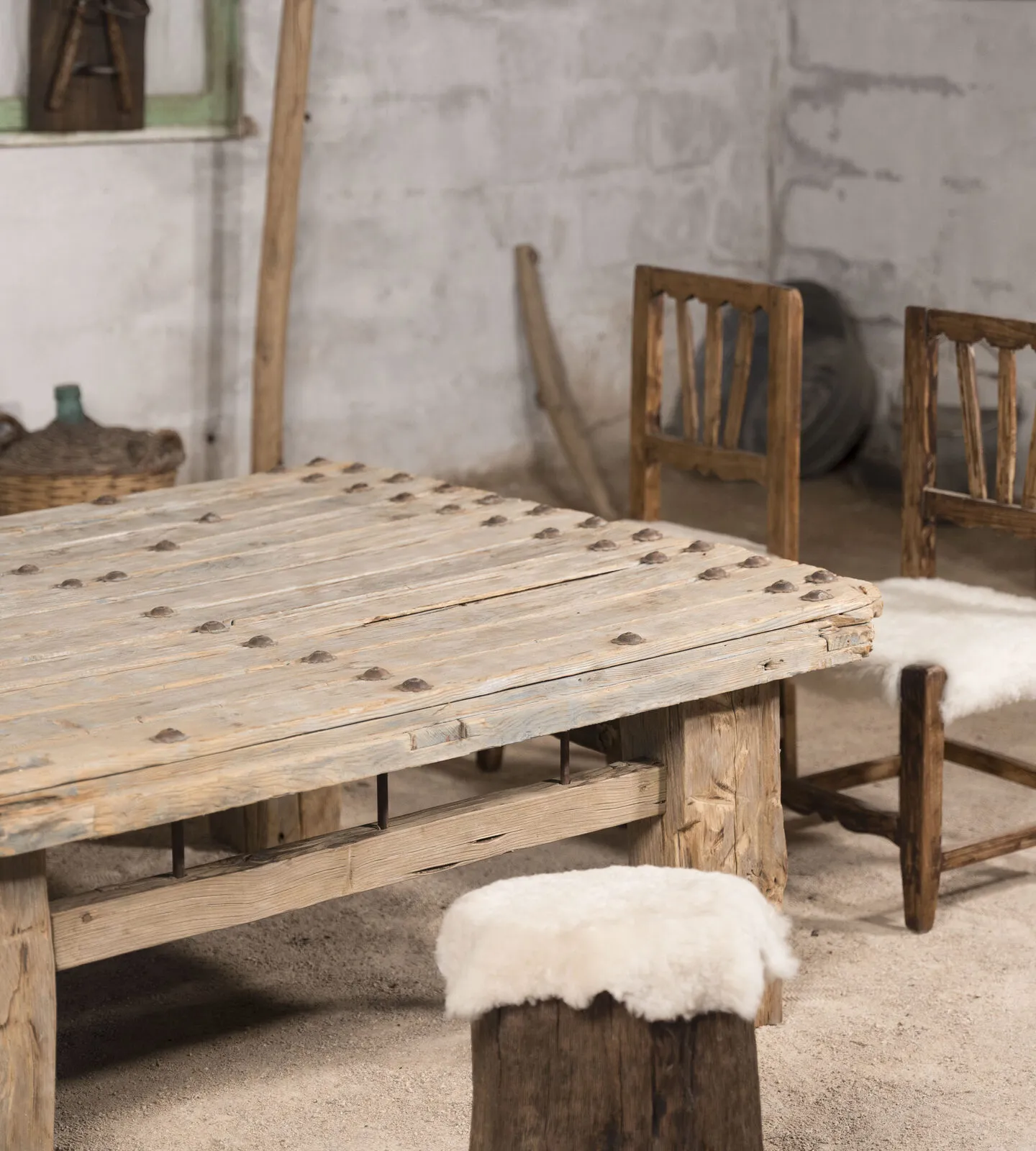 Mesa baja de tachuelas con dos sillas de madera y piel al fondo