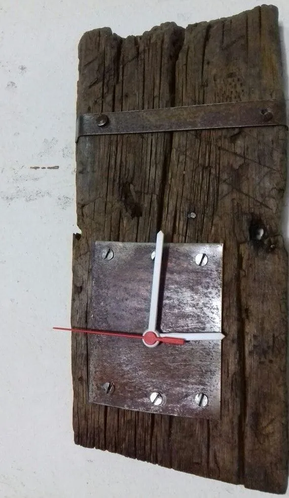 Reloj de pared hecho con una tabla vieja y una placa de metal atornillada